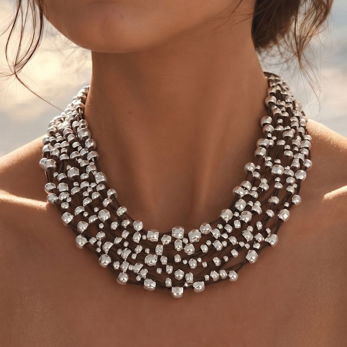 model trägt mehrreihiges Leder Collier in schwarz. Hintergrund : blauer Himmel