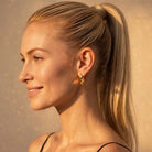 Model trägt Double Drop Tropfen-Ohrstecker aus Edelstahl in Gold 