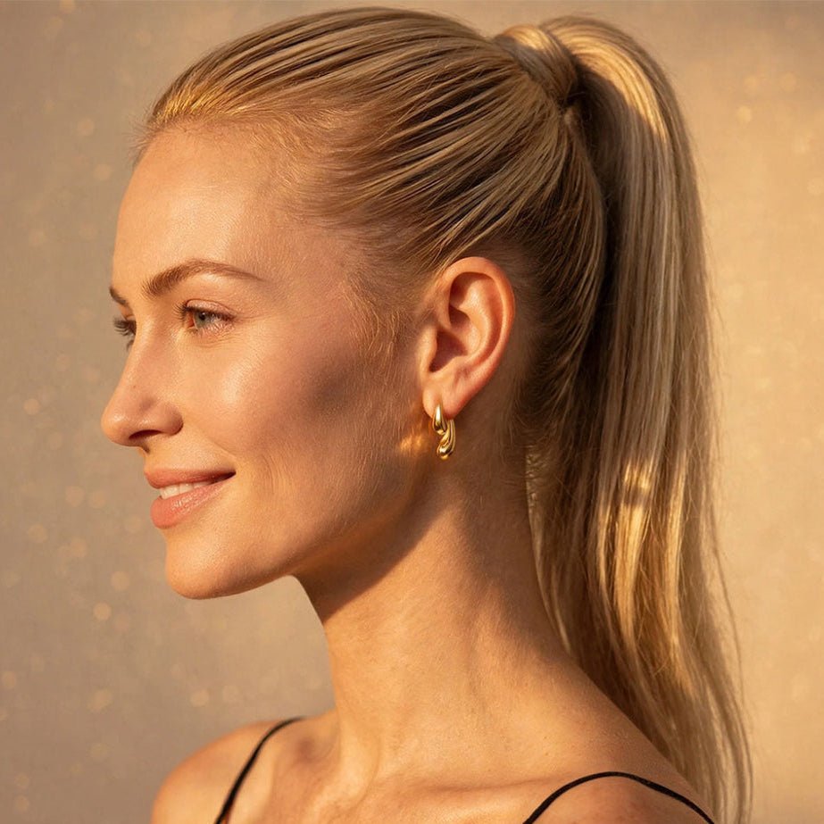 Model trägt Double Drop Tropfen-Ohrstecker aus Edelstahl in Gold 